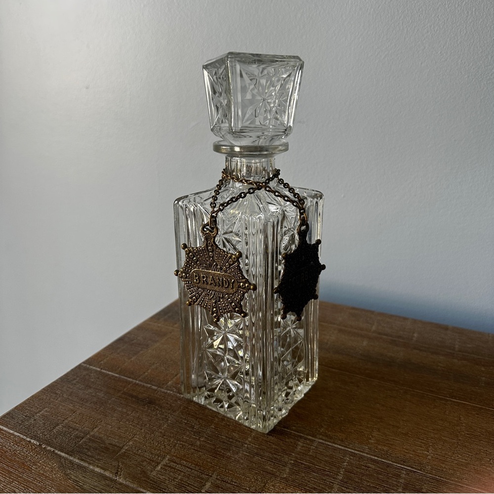 Vintage square cut-glass liquor decanter with a reversible metal medallions